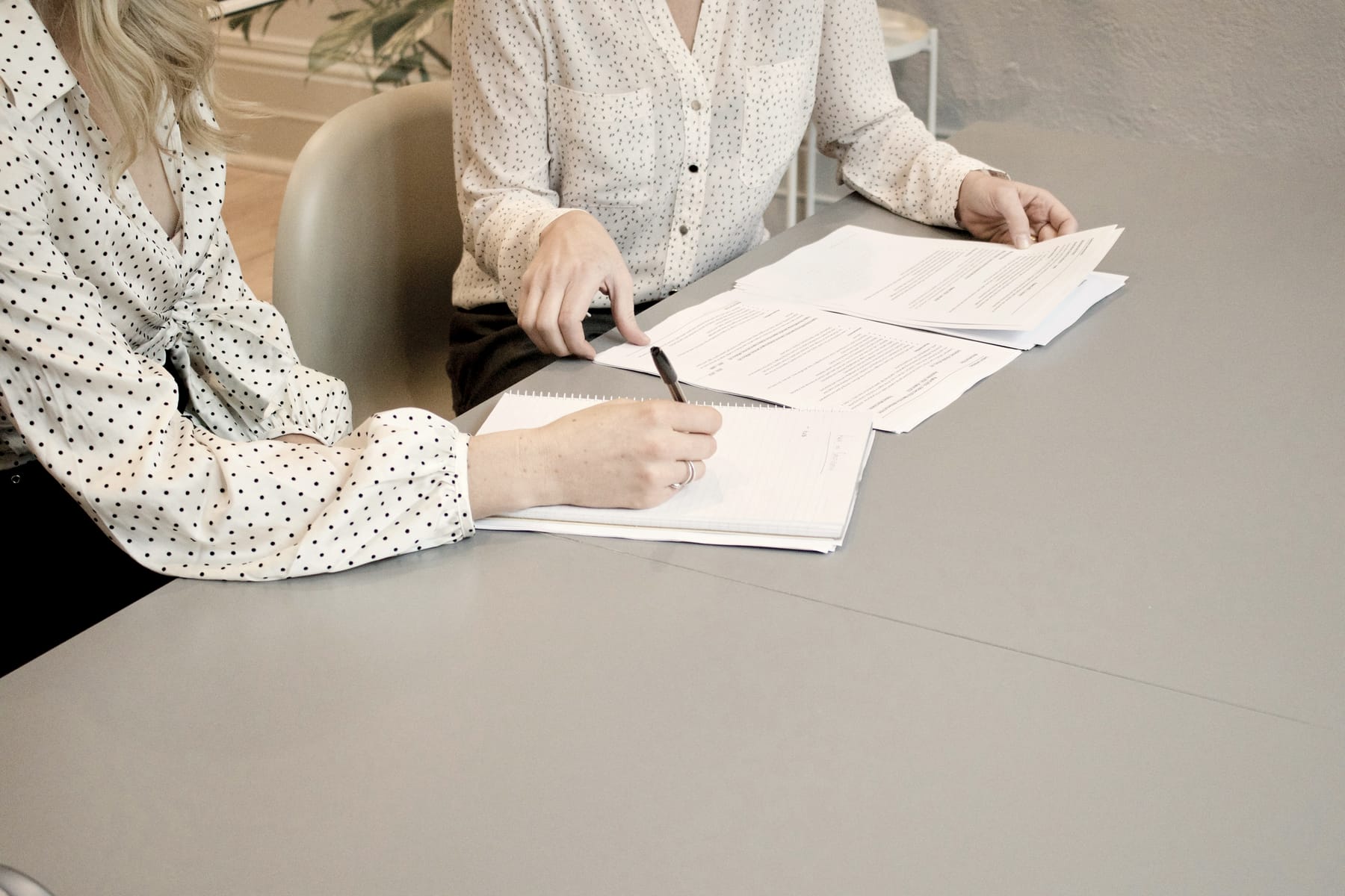 Two colleagues mark up a printed document together