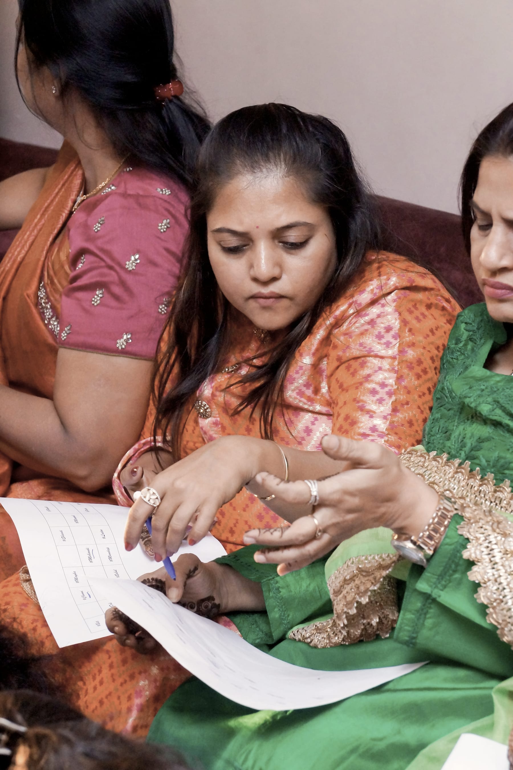 Three women go through notes they wrote by hand